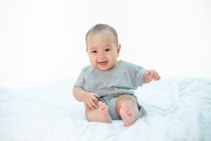 The baby is happy on the bed.
